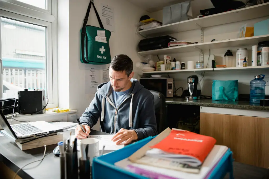 Mid adult fitness instructor is working in his office, writing new routines for his classes.