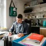 Mid adult fitness instructor is working in his office, writing new routines for his classes.