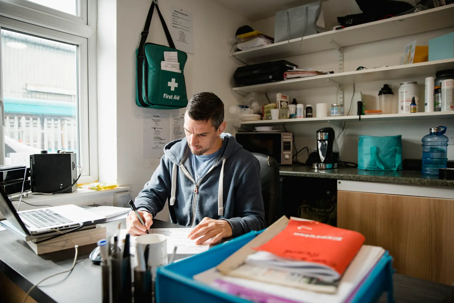 Mid adult fitness instructor is working in his office, writing new routines for his classes.