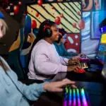 Young female gamer playing video game on a desktop computer at a competition