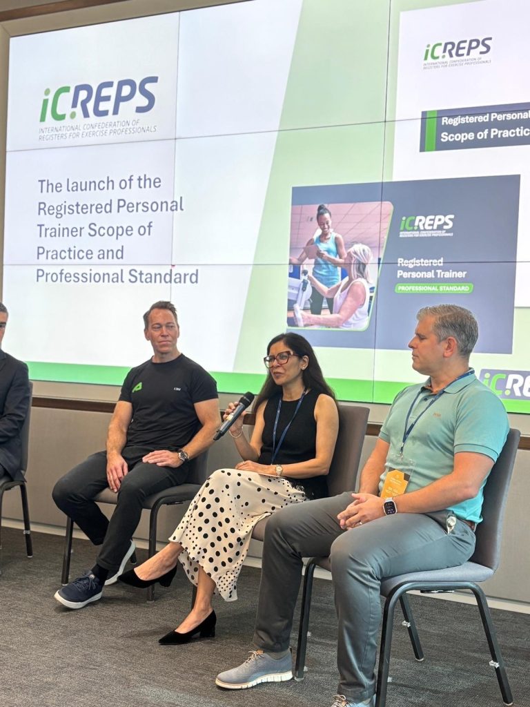 An expert seated in front of a presentation speaks into a microphone