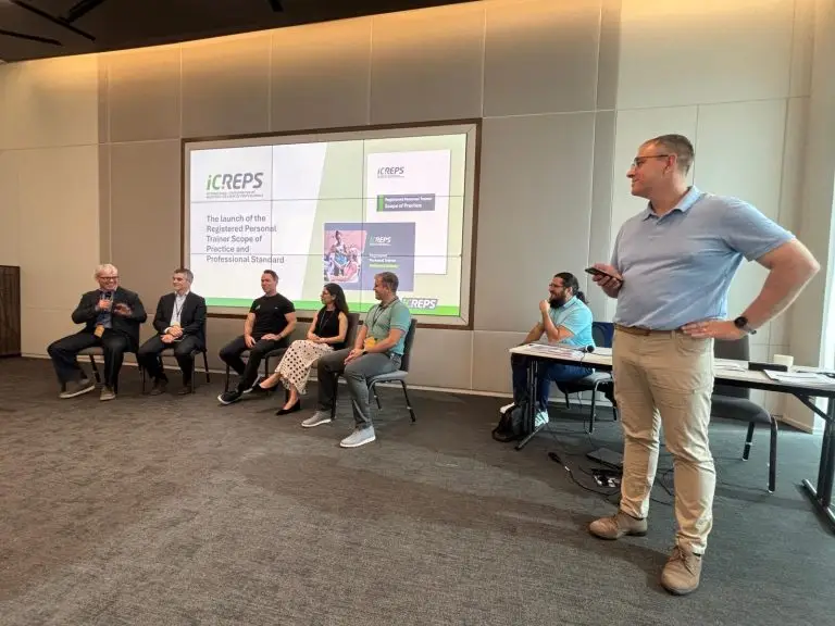 Spencer Moore stands beside a seated group of experts, leading a presentation