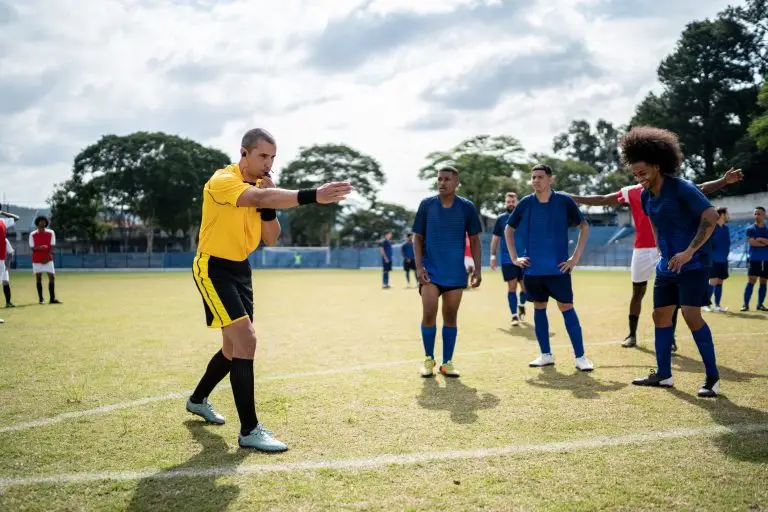 A referee blows the whistle during a football match