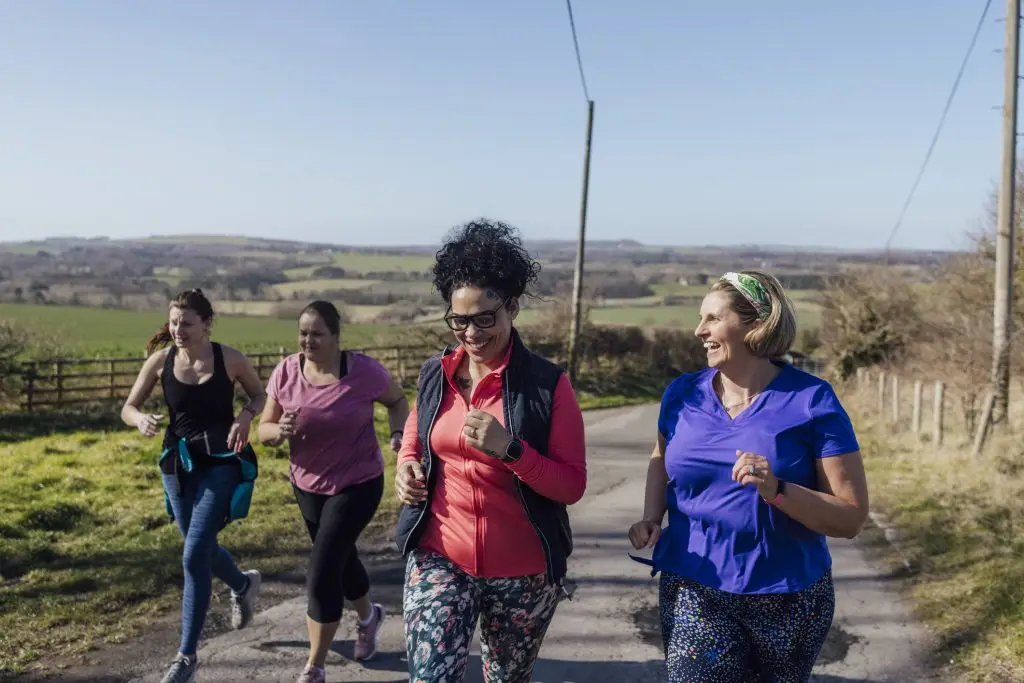 A group of women run in the countryside