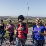 A group of women run in the countryside