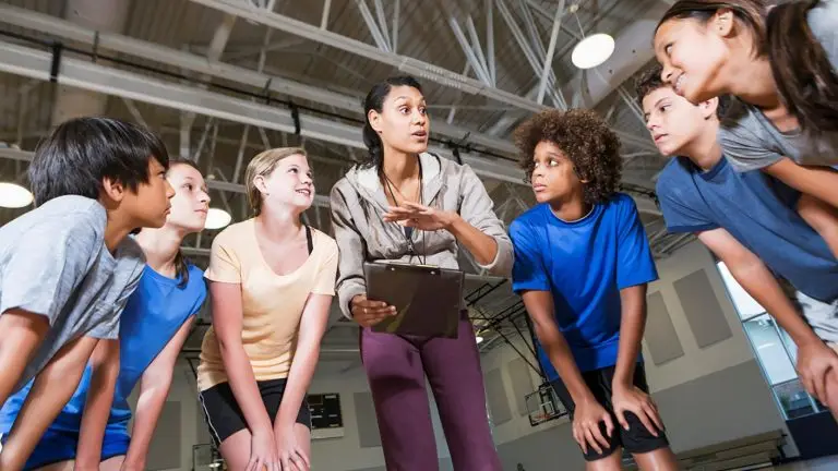 group of children listening to coach with clipboard
