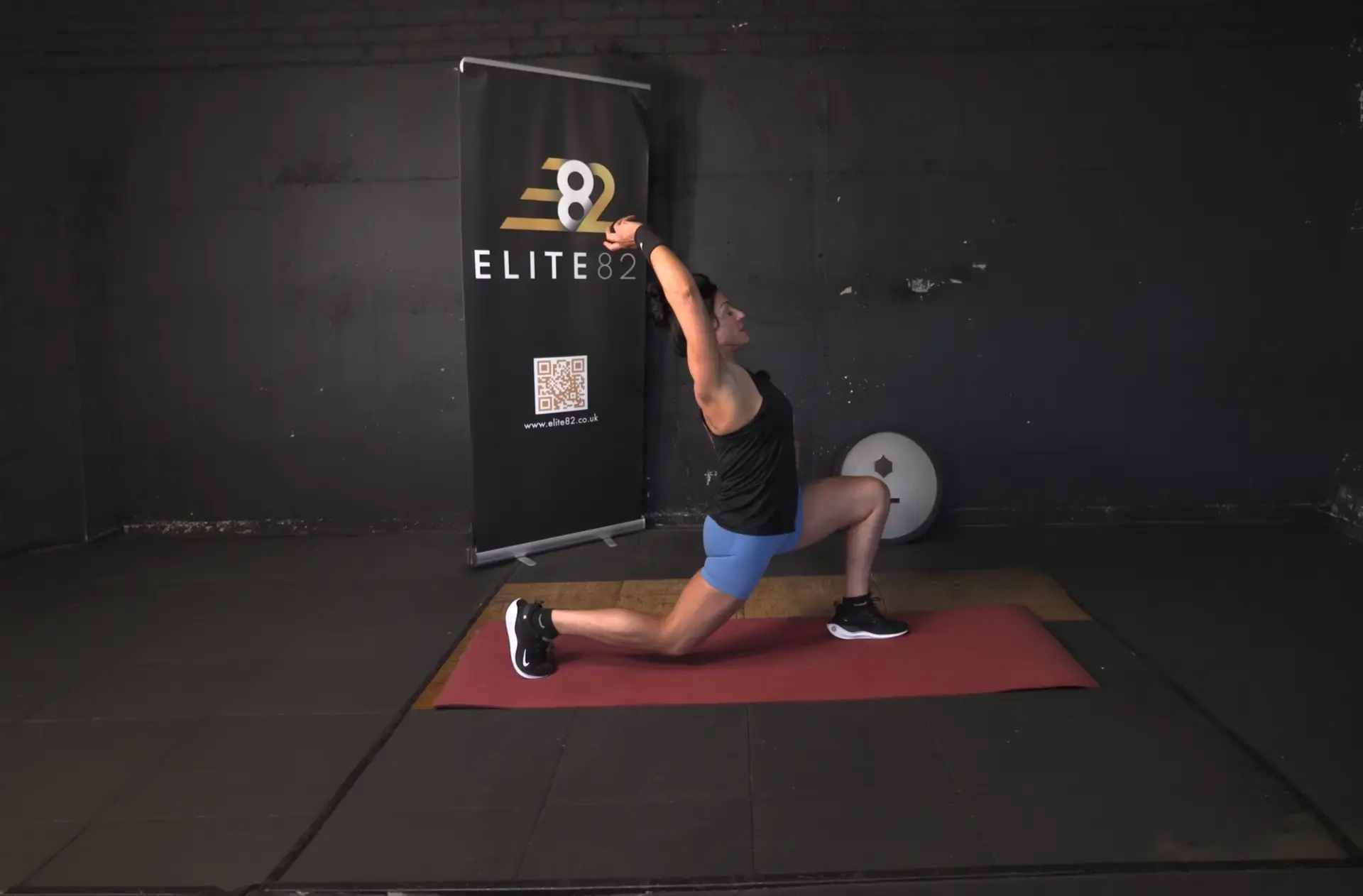 Sian stretches on a yoga mat in a deep lunge