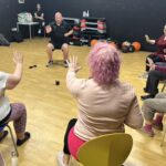 A chair-based exercise class in a gym