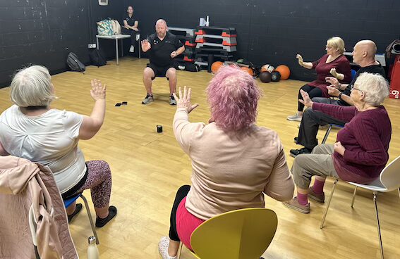 A chair-based exercise class in a gym