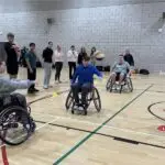 Young people play wheelchair basketball in a sports hall