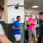 A group of young men stand in a circle chatting at a gym