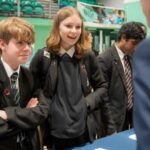Children at a careers fair engaging with a stallholder