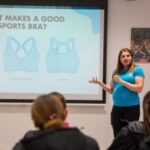 A woman presents a slide about types of sports bras