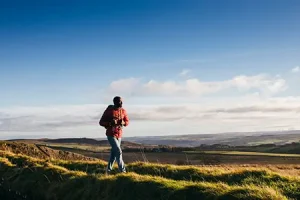 One young adult walking on Hadrian's Wall in Northumberland, UK countryside.