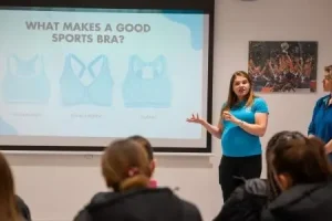 A woman presents a slide about types of sports bras